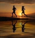 Silhouette of young sporty couple - man, woman jogger running on sunset beach. pair jogging on sea coast, sunrise. female jogging Royalty Free Stock Photo