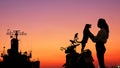 Silhouette young woman affectionately playing with her puppy dog and parrots couple on motorcycle at sea viewpoint in harbor with Royalty Free Stock Photo