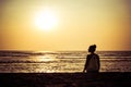 Silhouette of a young woman against the backdrop of the sunset and the big sun