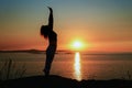 Silhouette of a young woman against sunset over the ocean Royalty Free Stock Photo