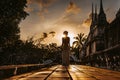 Silhouette of young woman walking at ancient temple at sunset