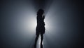 Silhouette girl dancing in darkness . Carefree woman having fun in dark space. Royalty Free Stock Photo