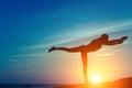 Silhouette of young woman doing exercises on the Ocean beach during sunset. Royalty Free Stock Photo