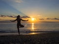 Silhouette of young woman doing exercises on the sea beach during sunset. Yoga, fitness and a healthy lifestyle Royalty Free Stock Photo