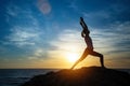 Silhouette of young woman doing exercises on the sea beach during sunset. Yoga Royalty Free Stock Photo