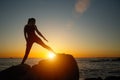 Silhouette of young woman doing fitness exercises on the beach at amazing sunset. Royalty Free Stock Photo