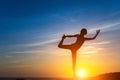 Silhouette of young woman doing fitness exercises on the sea beach during amazing sunset. Royalty Free Stock Photo