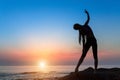 Silhouette of young woman doing gymnastics exercise at the sea Royalty Free Stock Photo