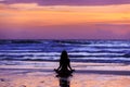 Silhouette young woman doing yoga on the beach at sunset Royalty Free Stock Photo