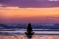 Silhouette young woman doing yoga on the beach at sunset Royalty Free Stock Photo