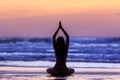 Silhouette young woman doing yoga on the beach at sunset Royalty Free Stock Photo
