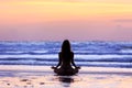 Silhouette young woman doing yoga on the beach at sunset Royalty Free Stock Photo