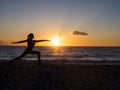 Silhouette of young woman doing yoga exersises on the beach at sunset. Meditation and yoga concept Royalty Free Stock Photo