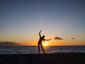 Silhouette of young woman doing yoga exersises on the beach at sunset. Meditation and yoga concept Royalty Free Stock Photo