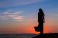 Silhouette of young woman in dress standing by the sea Royalty Free Stock Photo