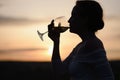 The silhouette of a young woman drinking wine in a sunset Royalty Free Stock Photo