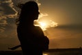 Silhouette of a young woman at sunset on the beach Royalty Free Stock Photo