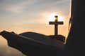 Silhouette of young woman hands holding holy Bible and lift of christian cross with light sunset background. christian concept Royalty Free Stock Photo