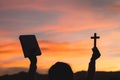 Silhouette of Young woman hands holding holy Bible and lift of christian cross, religion symbol in light and landscape over a Royalty Free Stock Photo