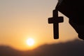 Silhouette of Young woman hands holding holy Bible and lift of christian cross, religion symbol in light and landscape over a Royalty Free Stock Photo