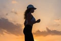 Silhouette of young woman jogging in the sport clothes on the sunset sky backgrounds. The concept of healthy lifestyle. Royalty Free Stock Photo