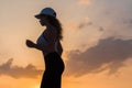 Silhouette of young woman jogging in the sport clothes on the sunset sky backgrounds. The concept of healthy lifestyle. Royalty Free Stock Photo