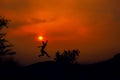 Silhouette of young woman jumping against sunset with copy space Royalty Free Stock Photo