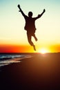 Silhouette young woman jumping with hands up on the beach at the Royalty Free Stock Photo