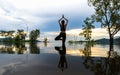 Silhouette young woman lifestyle exercising vital meditate and practicing reflect on Flood the trees in the reservoir, background