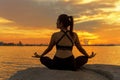 Silhouette young woman lifestyle exercising vital meditate and practicing yoga ball on the beach at sunset. Royalty Free Stock Photo