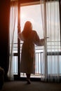 Silhouette of young woman looking out the window Royalty Free Stock Photo