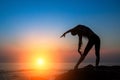 Silhouette of a young woman performing fitness exercises on the sea coast Royalty Free Stock Photo