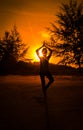 Silhouette young woman play yoga on the beach