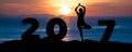 Silhouette young woman play Yoga on the sea and Happy New Year 2017 while celebrating new year