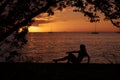 Silhouette of young woman posing in a wonderful sunset by the beach on her relaxing vacation Royalty Free Stock Photo