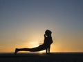 Silhouette young woman practicing pose yoga on swimming pool and the nature beach at sunset or sunrise. Yoga and Healthy Royalty Free Stock Photo