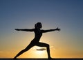 Silhouette young woman practicing pose yoga on swimming pool and the nature beach at sunset or sunrise. Yoga and Healthy Royalty Free Stock Photo