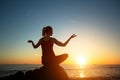 Silhouette young woman practicing yoga on the amazing sunset sea beach. Royalty Free Stock Photo