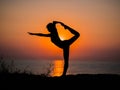 Silhouette young woman practicing yoga on the beach above sea at amazing sunset. fitness, sport, yoga and healthy Royalty Free Stock Photo