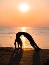 Silhouette young woman practicing yoga on the beach above sea at amazing sunset. fitness, sport, yoga and healthy Royalty Free Stock Photo