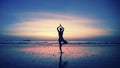 Silhouette of young woman practicing yoga on the beach at amazing sunset. Meditation Royalty Free Stock Photo