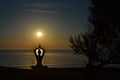 Silhouette of young woman practicing yoga on the beach Royalty Free Stock Photo