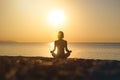 Silhouette young woman practicing yoga on the beach at sunset, Karon Beach ,Phuket ,Thailand. For background and texture Royalty Free Stock Photo