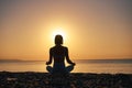 Silhouette young woman practicing yoga on the beach at sunset, Karon Beach ,Phuket ,Thailand. For background and texture Royalty Free Stock Photo