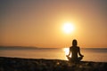 Silhouette young woman practicing yoga on the beach at sunset, Karon Beach ,Phuket ,Thailand. For background and texture Royalty Free Stock Photo