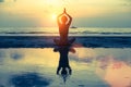 Silhouette young woman practicing yoga on the beach. Royalty Free Stock Photo