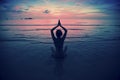 Silhouette young woman practicing yoga on the beach at surrealistic sunset. Royalty Free Stock Photo