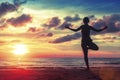 Silhouette young woman practicing yoga on the beach at surrealistic sunset. Royalty Free Stock Photo