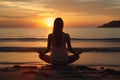 Silhouette of young woman practicing yoga and meditating at coastline beach Royalty Free Stock Photo