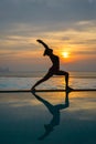 Silhouette young woman practicing yoga on swimming pool Royalty Free Stock Photo